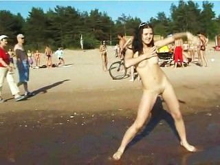एक न्यडिस्ट समुद्र तट पर नग्न दिलेर स्तन के साथ स्लिम किशोरों