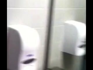 पुरुष एक सार्वजनिक शौचालय में बंद दिखा रहा है